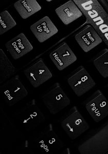 Detailed black and white close-up of a computer keyboard showing numeric keys and directional arrows.